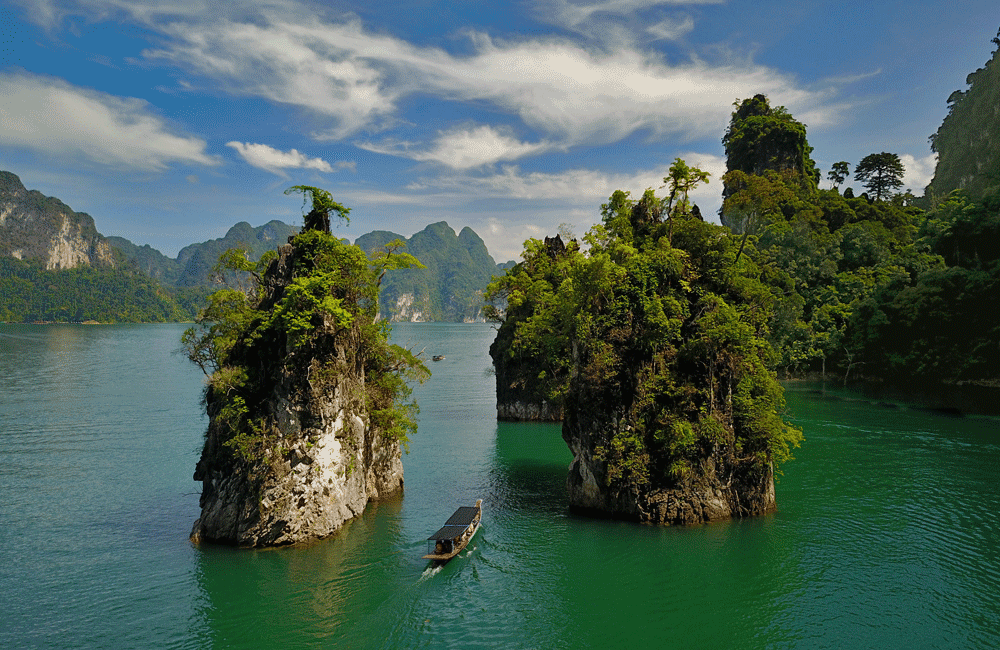 Limestone cliffs covered in lush vegetation rising from Cheow Lan Lake in Khao Sok National Park