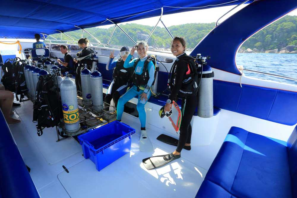 Happy scuba divers smiling onboard the Wave Rider speedboat in Khao Lak