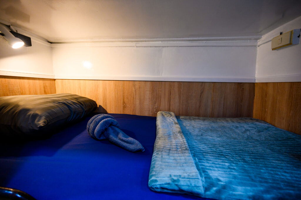 Bed in a berth cabin on MV Andaman liveaboard with overhead reading light